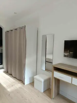 a white room with a mirror and a bed at Appartement studio in Nice