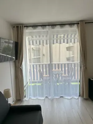a room with a window with a view of a balcony at Riviera Retreat - Steps to Beach & Shops, Balcony & AC in Saint-Laurent-du-Var