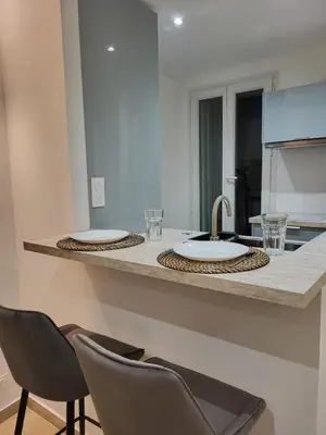 a kitchen counter with two chairs and a sink at Studio haut de gamme in Nice