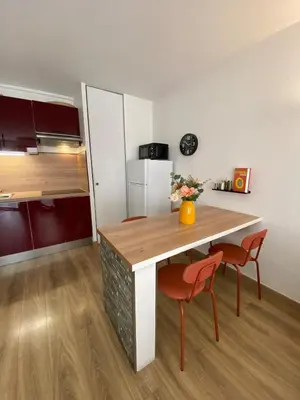 a kitchen with a table and two chairs and a refrigerator at Le Spot Niçois in Nice