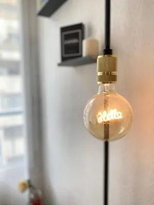 a glass light bulb hanging from a wall at Le Spot Niçois in Nice