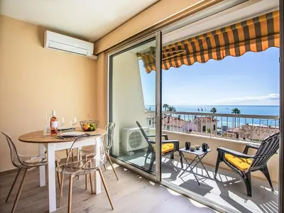 a dining room with a table and chairs and a balcony at Apartment Cros de Cagnes-2 by Interhome in Cagnes-sur-Mer
