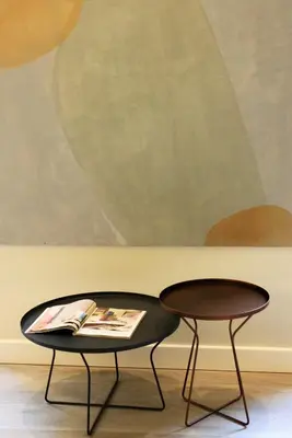 a table and two chairs in front of a painting at Les Suites Massena in Nice