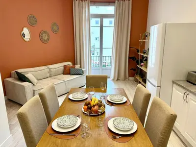 a dining room with a table and chairs and a living room at Harmonie Nature au cœur de Nice in Nice
