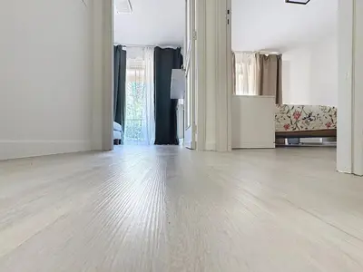 an empty room with a hard wood floor and windows at Azur Stay in Nice