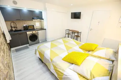 a bedroom with a large bed with yellow pillows at Cozy studio in Nice Désambrois in Nice