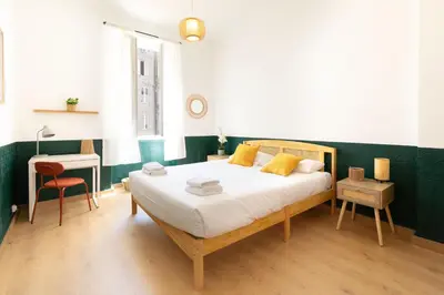 a bedroom with a bed and a table with a chair at Maison Bianchi - Downtown Nice Pertinax in Nice