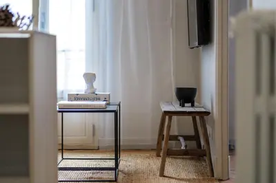 a table with a book and a vase on it at Appartement moderne proche mer et transports in Nice