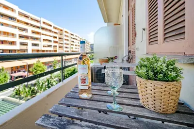 a bottle of wine and a glass on a table on a balcony at Studio moderne proche mer - Balcon et Climatisé in Nice