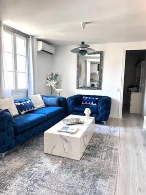a living room with a blue couch and a table at La vie est belle - T2 - Coeur de Nice in Nice