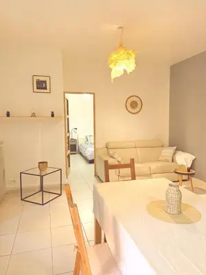 a living room with a table and a couch at 3 pièces près du Port de Nice in Nice