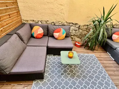 a purple couch with colorful pillows on a patio at Joli 2 pièces avec terrasse en centre ville in Nice