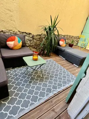 a patio with a couch and a table on a rug at Joli 2 pièces avec terrasse en centre ville in Nice