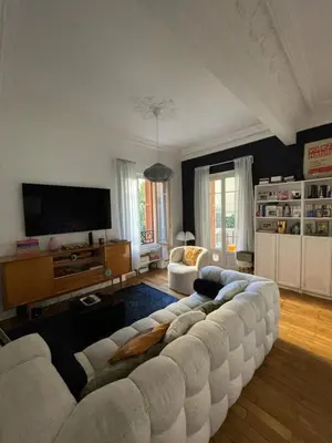 a living room with a white couch and a television at Palais Libération 3 pièces in Nice