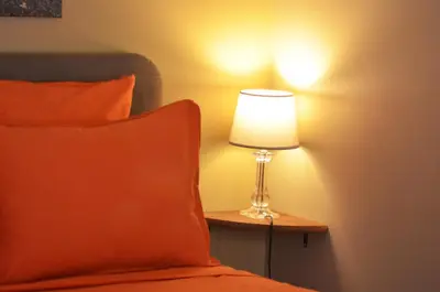 a lamp sitting on a table next to a bed at Rivoli Center Terrasse Clim Parking in Nice