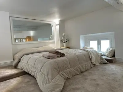 a bedroom with a large bed with a large mirror at Gaya in Nice