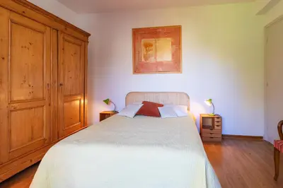 a bedroom with a large white bed and wooden cabinets at ALTAIR AP4466 by RIVIERA HOLIDAY HOMES in Nice