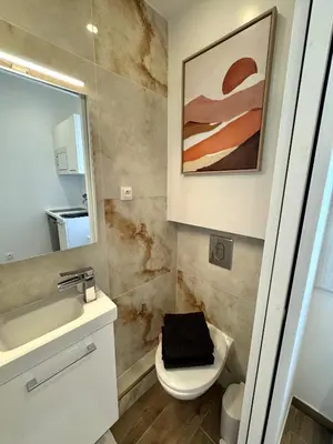 a bathroom with a sink and a toilet and a mirror at Cosy studio le port in Nice