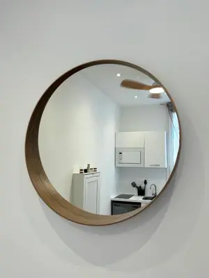 a kitchen with a mirror on a white wall at Cosy studio le port in Nice