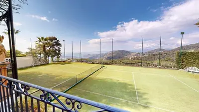 a tennis court with a tennis racket on it at Villa Ezea - vue mer et charme in Èze