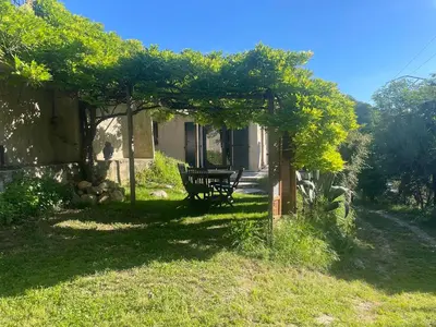 a bench sitting under a pergola in a yard at La Petite Maison des Baous in Saint-Jeannet