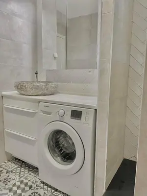a bathroom with a washing machine and a sink at La Petite Maison des Baous in Saint-Jeannet