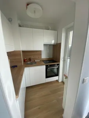 a small kitchen with white cabinets and a sink at Vacances à la mer in Cagnes-sur-Mer