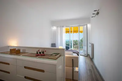 a white room with a window and a bedroom at VISTA MARE AP4459 By Riviera Holiday Home in Villefranche-sur-Mer