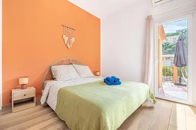 a bedroom with a bed with an orange wall at Maison 6-7p, Terrasses, proche Plages, Nice Centre in Nice