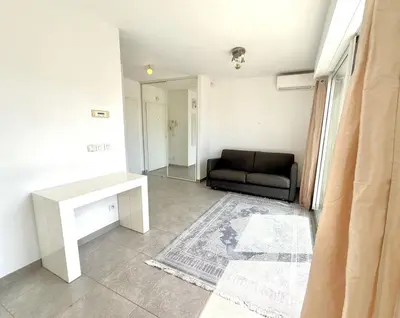 a living room with a couch and a table at Studio Terrasse 3ème étage, climatisation coeur de Nice in Nice