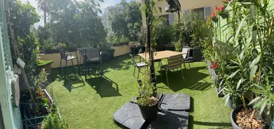 a garden with a table and chairs and plants at Chambre Vue Jardin Alsace Lorraine Victor Hugo in Nice