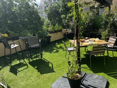 a garden with a table and chairs on the grass at Chambre Vue Jardin Alsace Lorraine Victor Hugo in Nice
