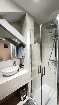 a bathroom with a sink and a glass shower at Appartement moderne & calme proche mer et centre in Nice