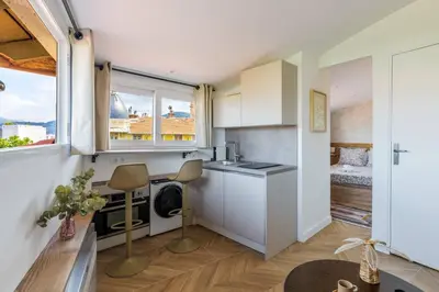 a kitchen with white cabinets and a window at 12, Boulevard Jean Jaures - Studio in Nice