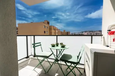 a balcony with a table and chairs on a roof at Le Neoroch in Nice