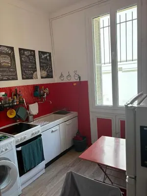 a kitchen with a white stove and a red wall at Studio spacieux - Centre de Nice, proche mer & gare in Nice