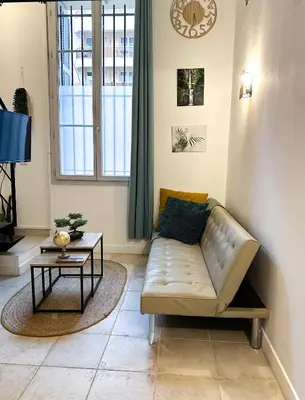 a living room with a couch and a table at AngeVert HolidayHouse in Nice