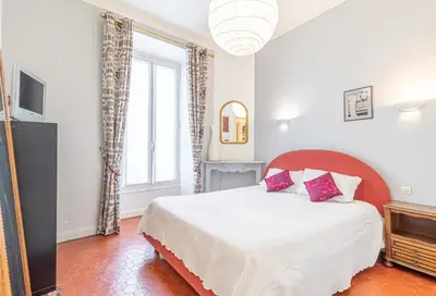 a bedroom with a bed and a large window at Suite Bottero in Nice