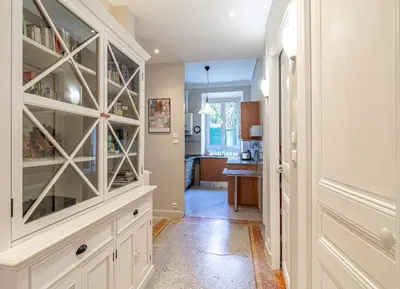 a kitchen with white cabinets and a hallway at Suite Bottero in Nice