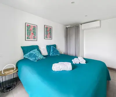 a bedroom with a blue bed with blue pillows at Havre de paix avec terrasse in La Gaude