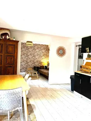 a living room with a table and a couch at Le Bohème 3 pièces jardin in Saint-Laurent-du-Var