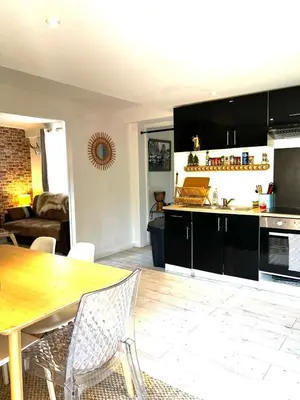 a kitchen and living room with a wooden table at Le Bohème 3 pièces jardin in Saint-Laurent-du-Var