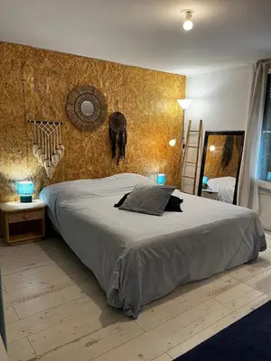 a bedroom with a large bed and a wall at Le Bohème 3 pièces jardin in Saint-Laurent-du-Var