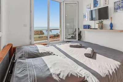 a living room with a kitchen and a table at L'Azur - Seaview - AC - Tram - WIFI - Airport in Nice