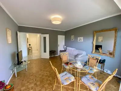 a living room with a table and a couch at Nice West Pretty one bedroom in Nice