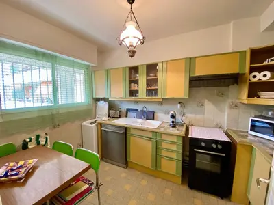 a kitchen with yellow and green cabinets and a table at Nice West Pretty one bedroom in Nice