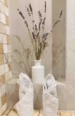 a vase with purple flowers in a bathroom with towels at Bella Nissa Bnb - AC wifi - cosy - 2 bedrooms in Nice