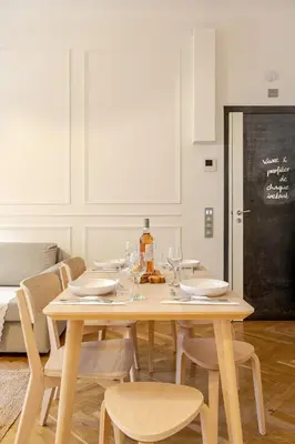 a wooden table with chairs and wine glasses on it at Bella Nissa Bnb - AC wifi - cosy - 2 bedrooms in Nice