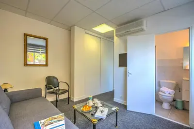 a living room with a couch and a toilet at Castel du Port - Happy Rentals in Saint-Laurent-du-Var