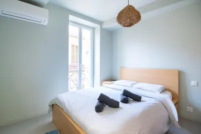 a bedroom with a bed with two pillows on it at Spacieux et Moderne T2 - Hyper Centre in Nice